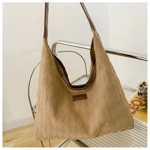 Détail du sac hobo kaki avec texture matelassée et bandoulière en cuir sur chaise