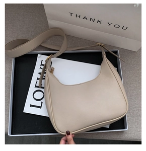 Detail view of beige crescent hobo bag with gold zipper and stylish matching shoulder strap