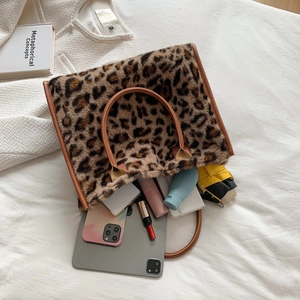 Faux fur leopard print tote bag with brown handles showing large storage capacity