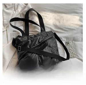 Quilted black down tote bag with nylon finish and adjustable shoulder strap detail