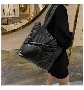 Close-up of the black padded puffer tote bag showing water-resistant nylon fabric and quilting
