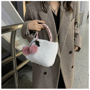 Detail of white plush faux fur bucket bag with pink braided handle and gold chain