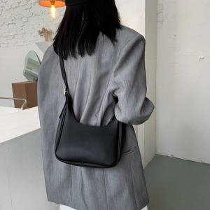 Minimalist black crescent hobo bag for women shown as a stylish shoulder bag on a model