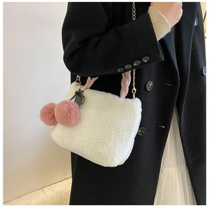 Detail of white plush cherry bucket bag with golden chain strap on a black wool coat