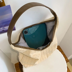 Sac cabas hobo matelassé beige avec bandoulière en cuir brun et intérieur spacieux