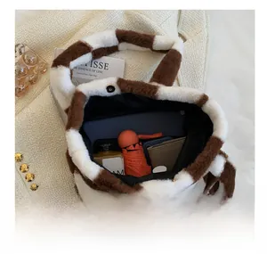 Spacious interior of fuzzy checkered tote bag holding laptop, umbrella, and daily items