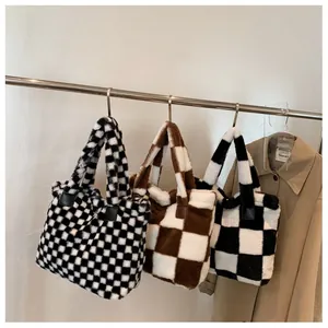 Three plush checkerboard tote bags hanging on a rack showing faux fur texture