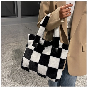 Detail of checkered plush tote bag with reinforced handles and soft faux fur texture