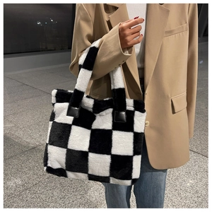 Fluffy checkerboard laptop tote bag carried by a model in a professional office setting