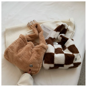 Detail of plush faux fur tote bags with checkered pattern and metallic buckle closures