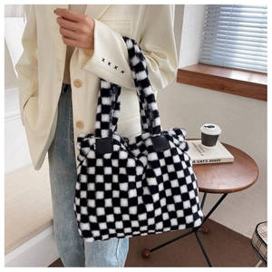 Close-up of black and white checkerboard plush tote bag with soft faux fur texture