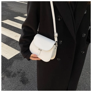 Close-up of white saddle bag with metal buckle on a black double-breasted coat