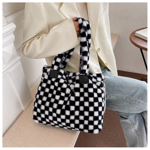 Close-up of black and white checkered fuzzy tote bag showing plush texture and leather strap