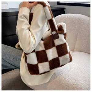Close-up of plush brown and white checkered tote bag carried by a model in a minimal setting