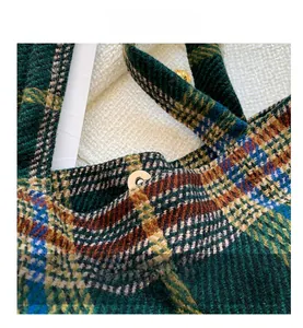 Detailed view of the magnetic closure and textured green tartan fabric of the tote bag
