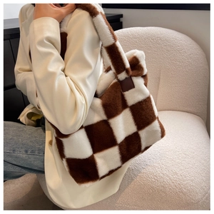 Brown and white checkered faux fur tote bag showing soft texture on a model