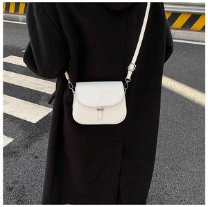 Detailed view of a white minimalist saddle bag in PU leather with adjustable shoulder strap