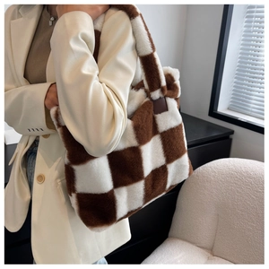 Checkered plush tote bag detail showing brown and white faux fur texture and thick shoulder strap