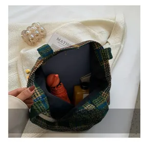 Spacious interior of plaid tweed tote bag holding tablet, umbrella and water bottle