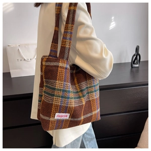Detail of vintage plaid tote bag with FASHION label on minimalist modern home background