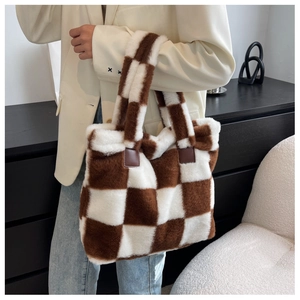 Detailed view of plush checkered tote bag with brown leather reinforced handle straps
