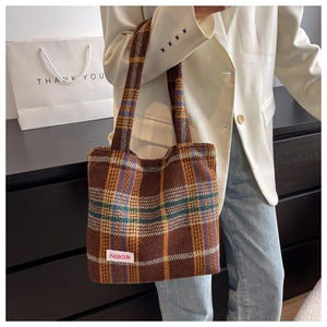 Detail of checkered tweed tote bag with a woven Fashion label in retro style