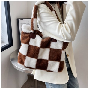 Detail of checkered plush tote bag featuring soft faux fur texture and brown leather patches