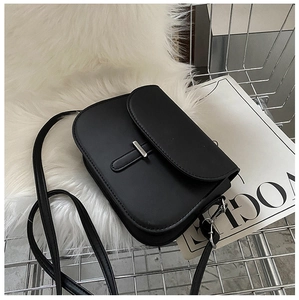 Detail of black matte saddle bag with silver buckle sitting in a metal shopping cart