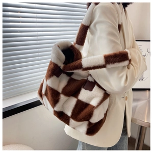 Detail of brown and white checkered fuzzy tote bag with soft faux fur texture