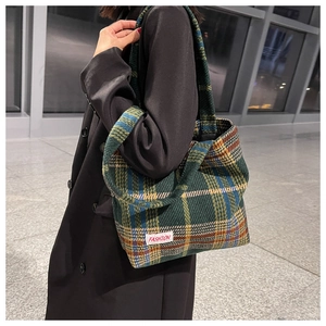 Close-up of a plaid wool tote bag with a white Fashion tag and thick woven texture