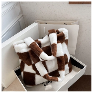 Detail of checkered plush tote bag in brown and white inside a premium gift box