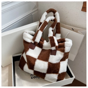 Detail of checkered plush tote bag with faux fur texture and brown leather handles