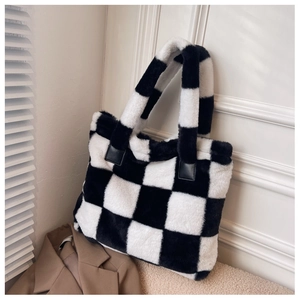 Close-up of black and white checkerboard plush tote bag with soft faux fur texture