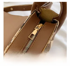 Macro view of brown leather bag with golden zipper and classic plaid fabric lining