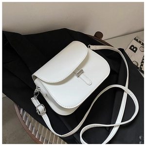 Detail view of white leather saddle bag with silver metal bar buckle on black blazer
