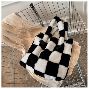 Detailed texture of black and white checkerboard plush tote bag inside a metal basket