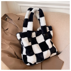 Detail shot of the fuzzy black and white checkerboard tote bag with soft faux fur texture