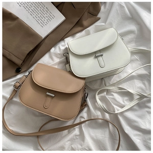 Close-up of retro saddle bags in khaki and cream PU leather with metal buckle detail
