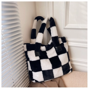 Detail shot of fluffy black and white checkerboard tote bag with soft faux fur texture