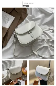 Macro detail of white faux leather saddle bag featuring elegant silver metal clasp buckle