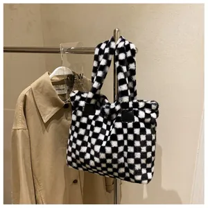 Close-up of black and white checkered fuzzy tote bag with soft faux fur texture and leather straps