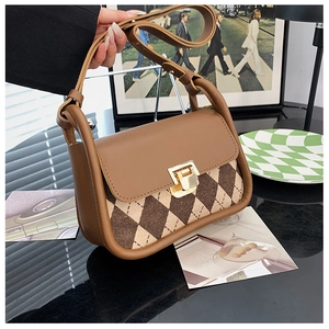 Detail showing vintage plaid saddle bag texture with brown faux leather and metal clasp