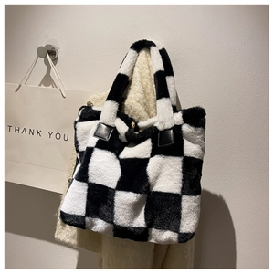 Close-up of black and white checkerboard plush tote bag with reinforced leather handles