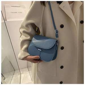 Close-up of Morandi blue saddle bag with matte leather and silver metal bar detail