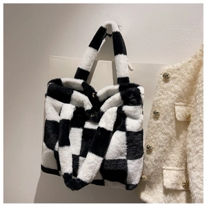 Close-up of plush checkerboard laptop bag with a gold magnetic clasp and soft texture