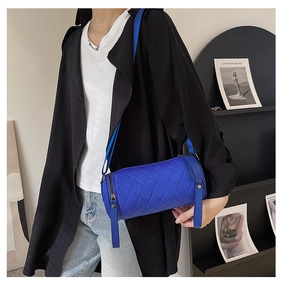 Close-up of bright blue quilted nylon cylinder bag with black zipper detail