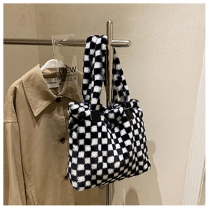 Close-up of black and white checkerboard plush tote bag with soft fuzzy texture