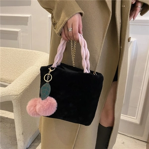 Chic black plush bucket bag with pink woven handle and cherry charm pendant