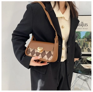 Detail view of vintage brown plaid saddle bag with golden metal clasp and adjustable strap