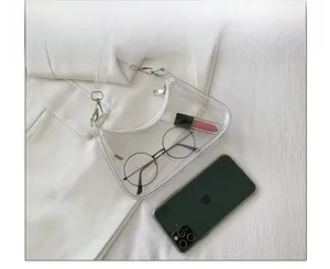 Detailed view of clear PVC shoulder bag showing storage space for glasses and lip gloss